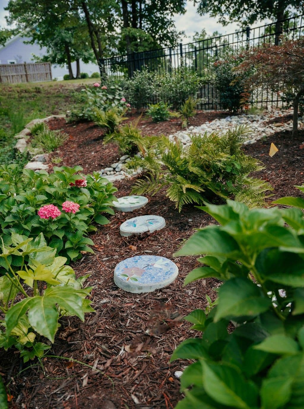 Stepping stones through a bed of hydrangeas and groundcover.