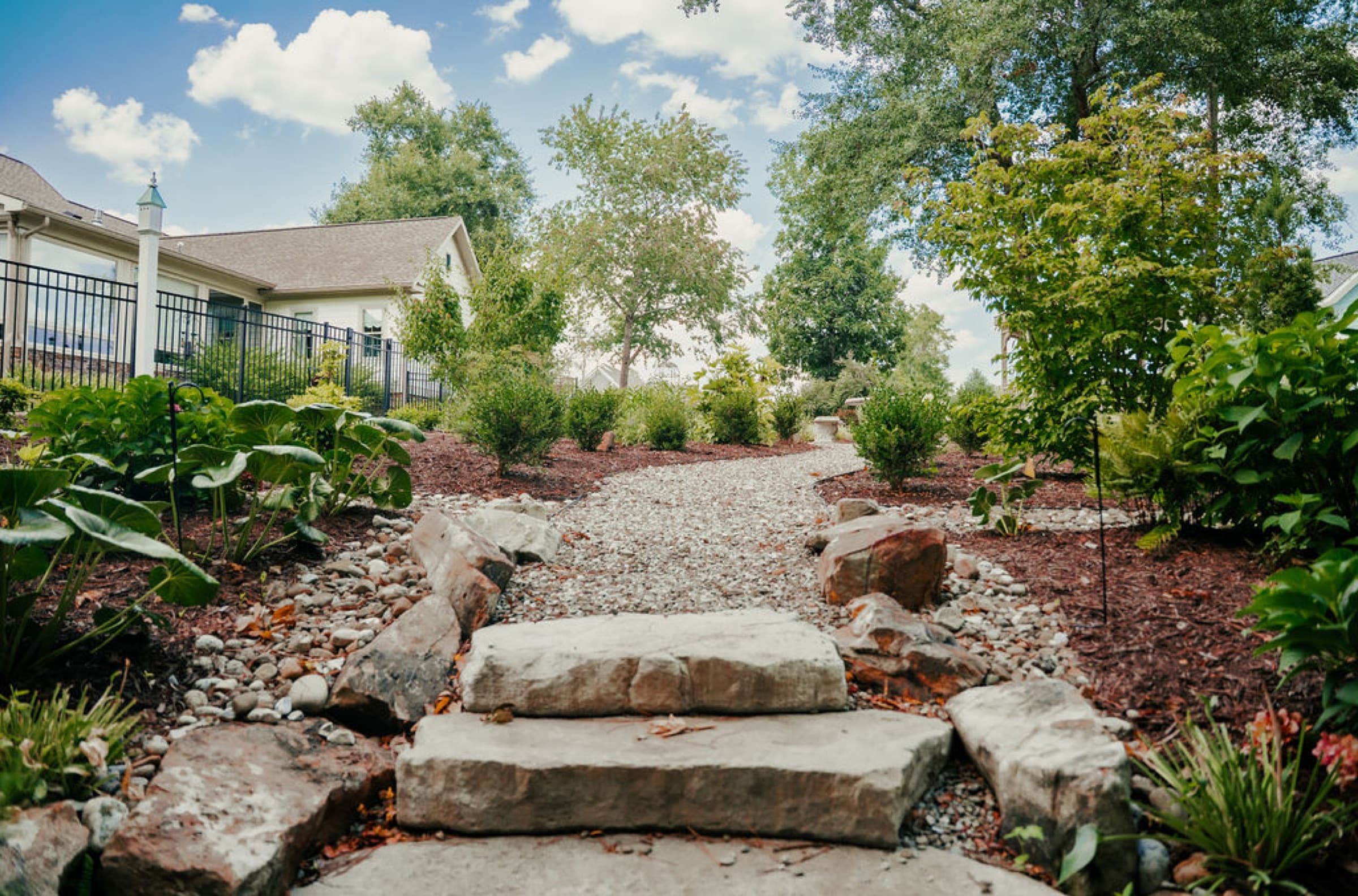 Natural stone steps and a gravel path through planting beds.